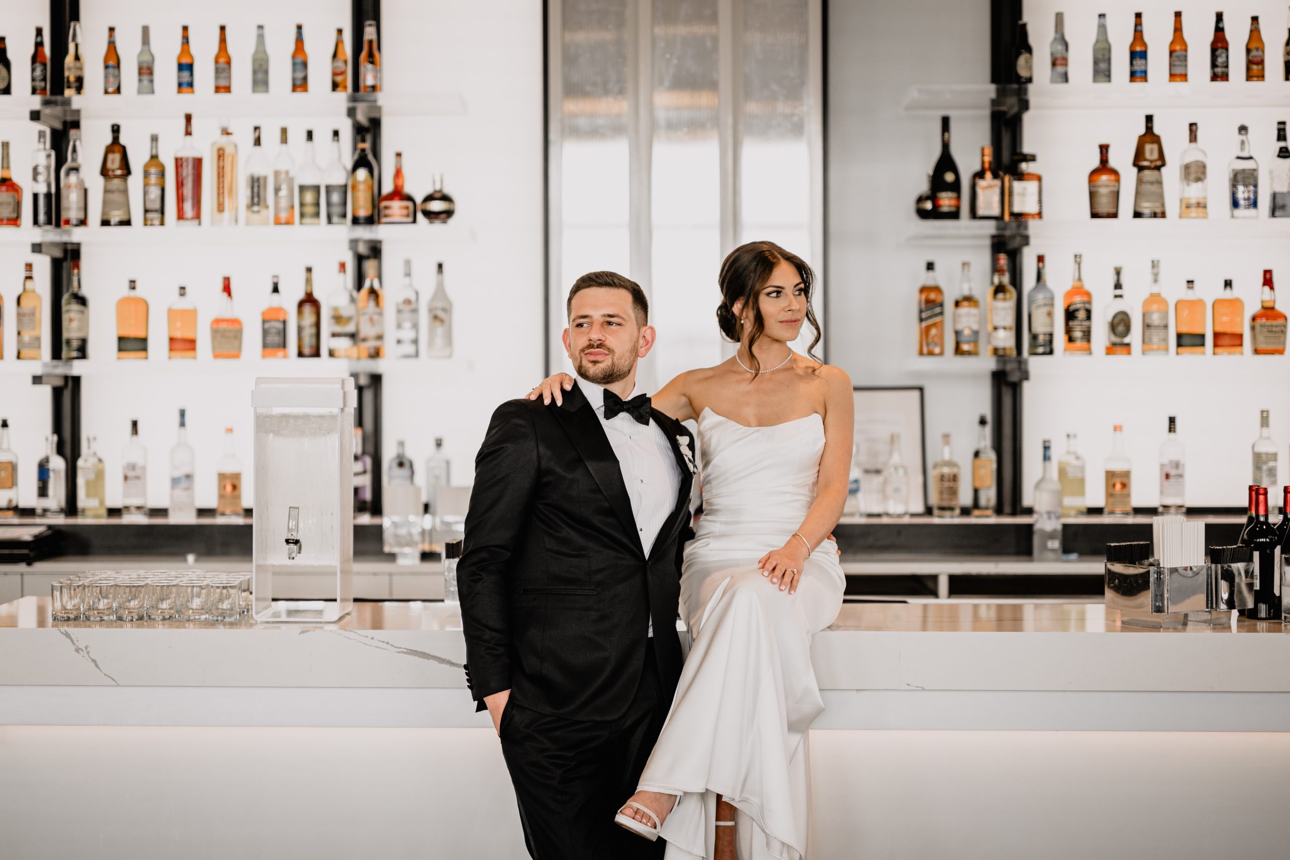 couple at the bar while the bride sits on the counter during weddings at Tribeca Rooftop in New York City