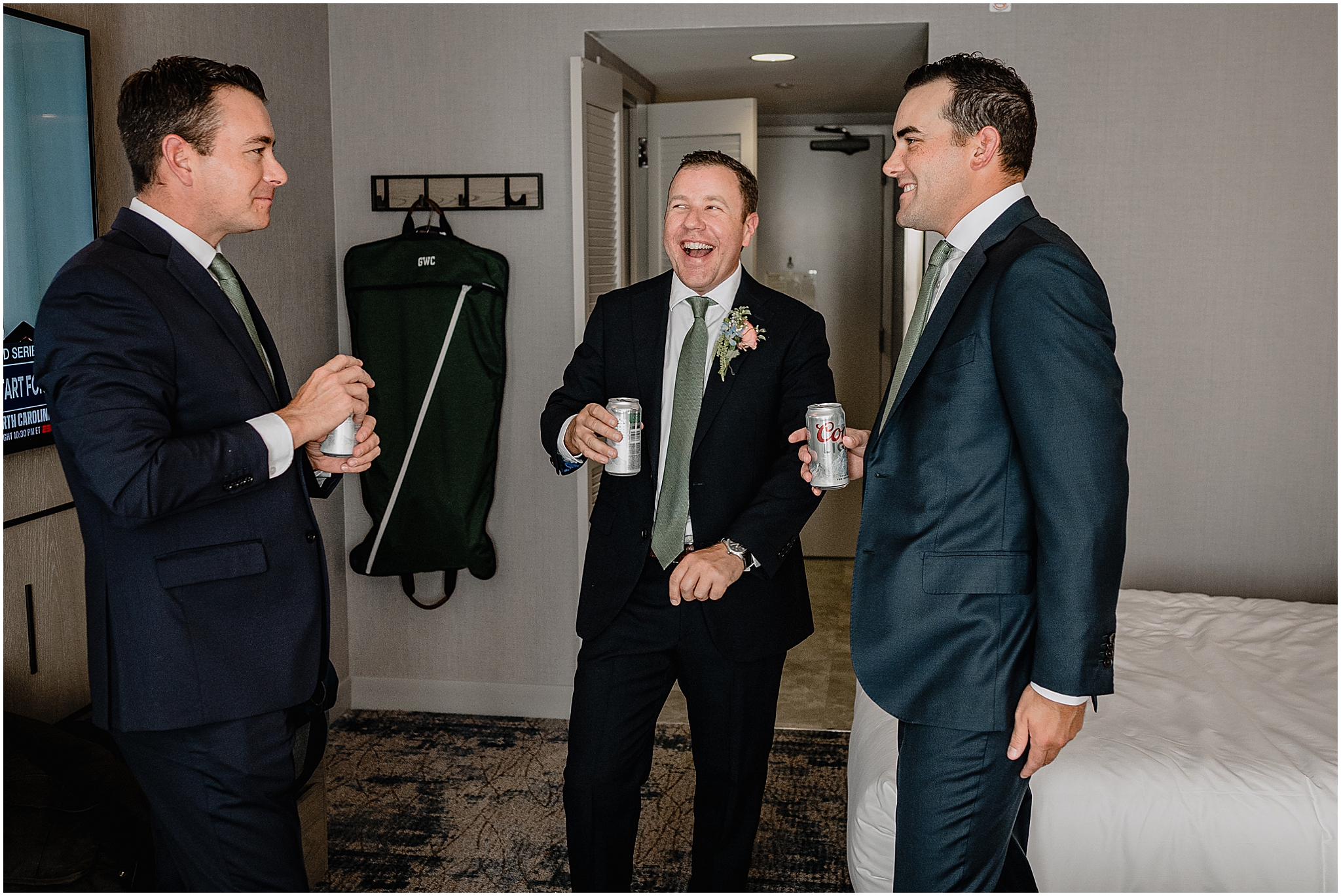 Groom laughing and enjoying a drink with his groomsmen before the ceremony at their Colorful Fall Wedding at Liberty House.