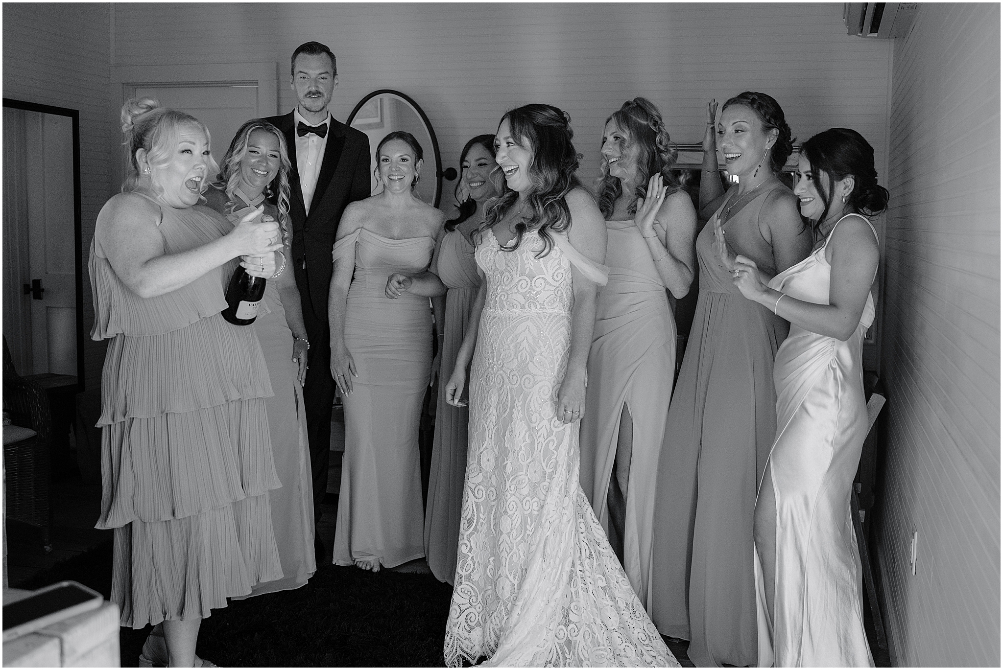 Bridal party celebrating with champagne during their summer wedding at Waterloo Village.
