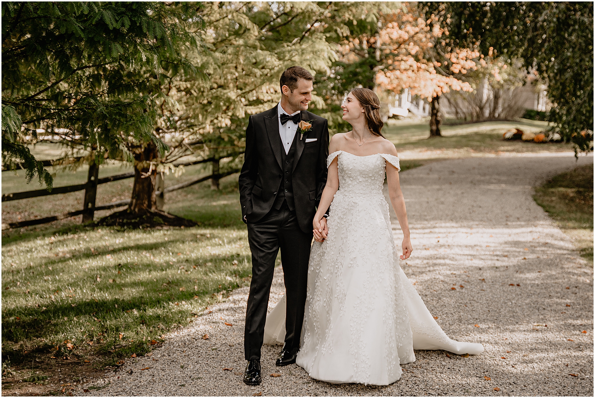Couple walking hand-in-hand down a road before their fall wedding at Crossed Keys Estate.