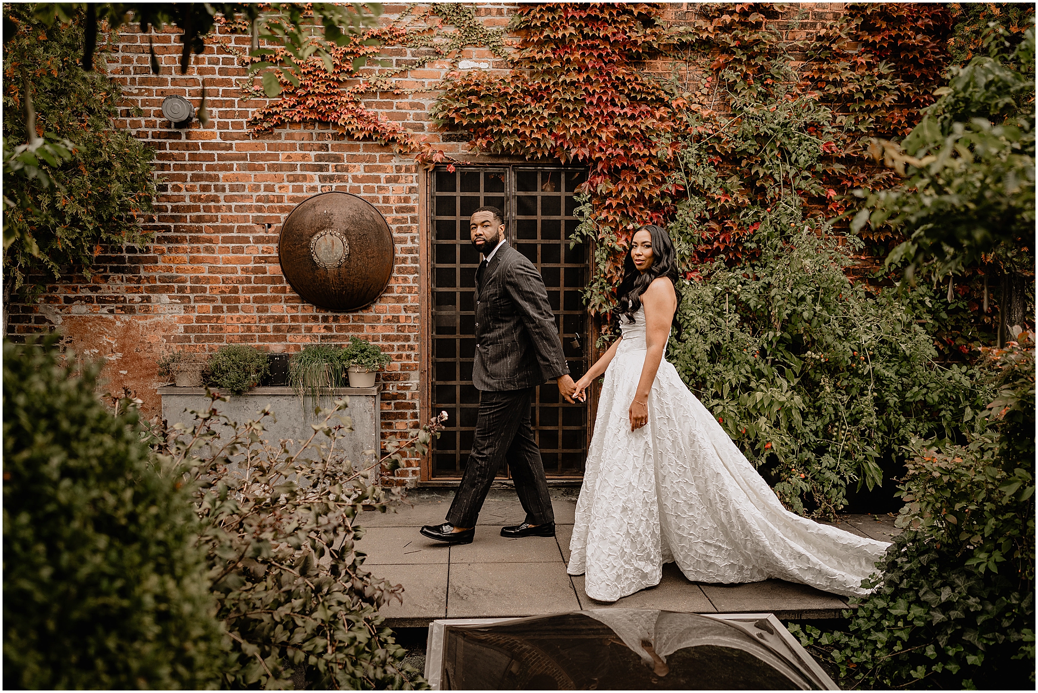 Couple walking hand in hand during their Intimate Fall Wedding at The Foundry LIC, surrounded by autumn foliage and natural beauty.