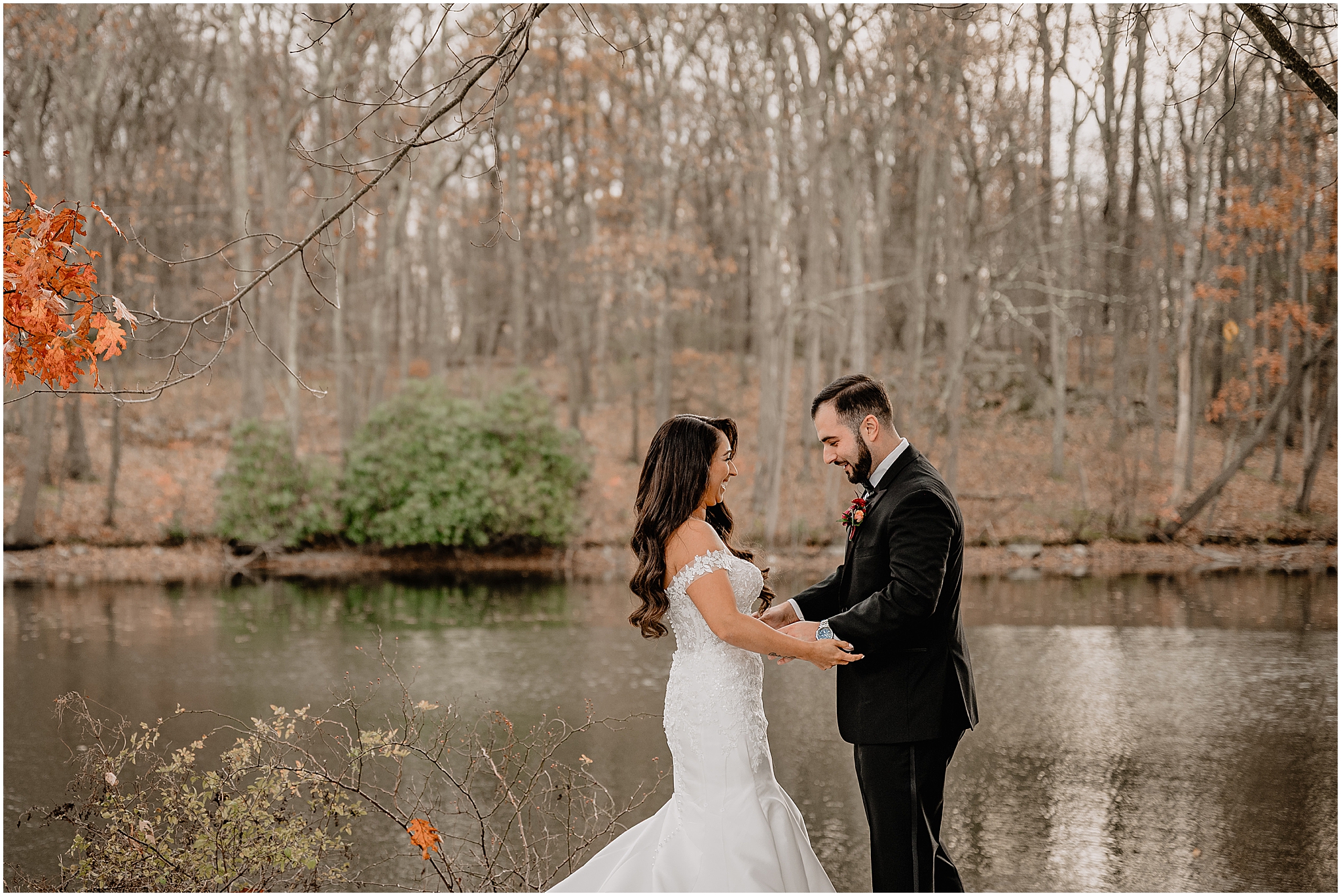 Couple’s first look by the lake during a fall wedding at Perona Farms Refinery, sharing an intimate and emotional moment together.