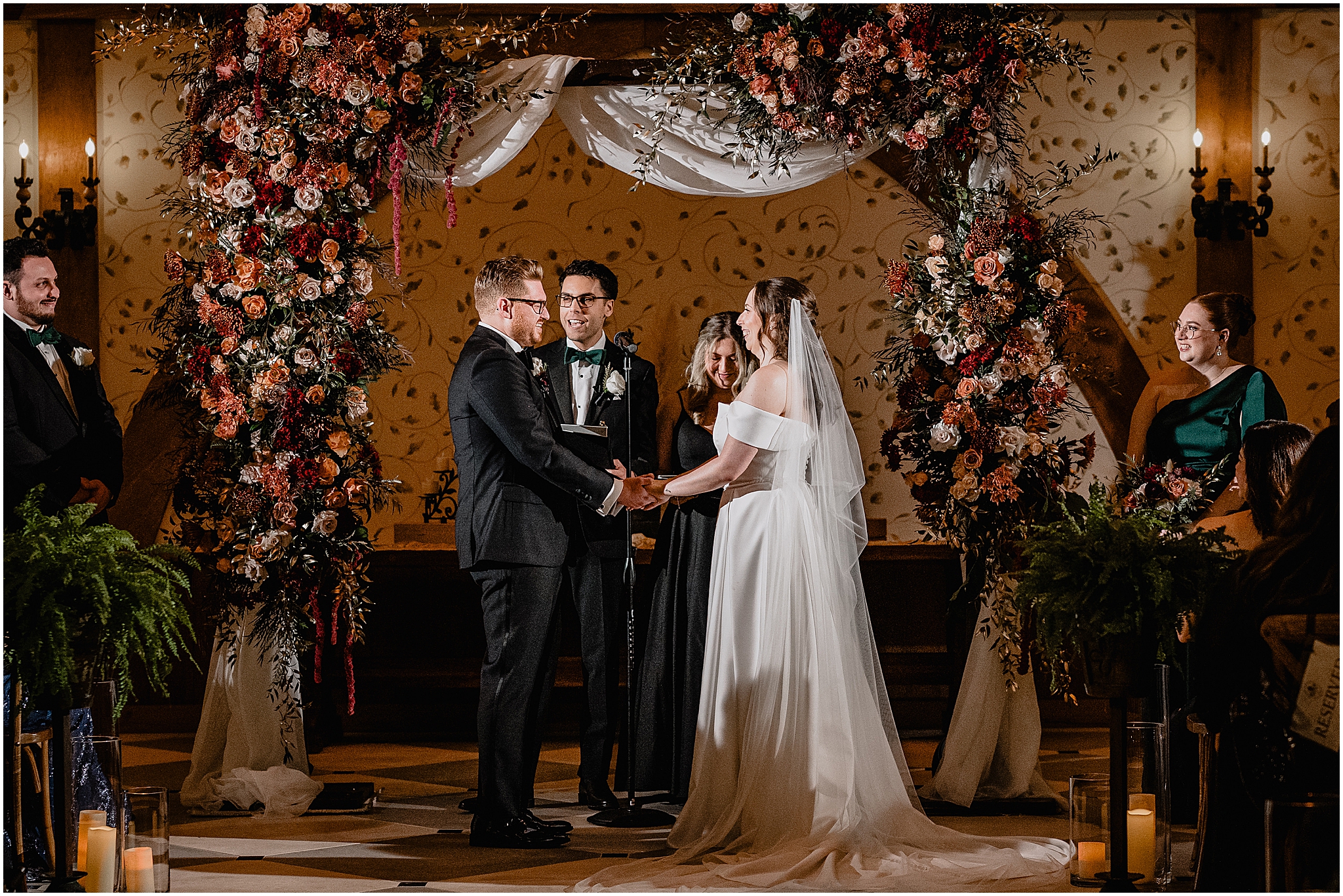 Couple at the altar holding hands during their halloween wedding at Pleasantdale Chateau.