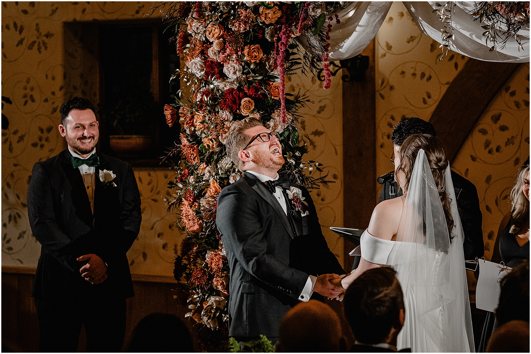 Couple at the altar holding hands during their halloween wedding at Pleasantdale Chateau