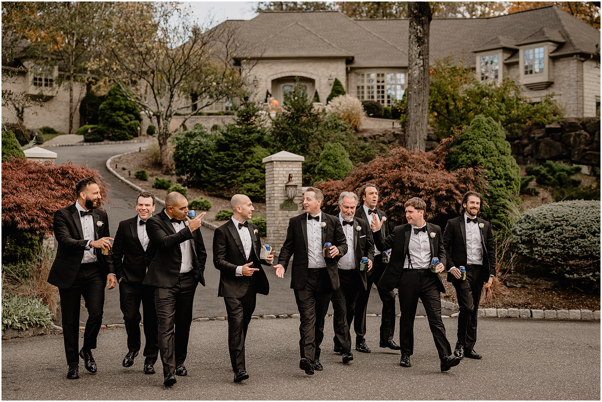 Groom walking with his groomsmen while holding a beer before his Westmount Country Club wedding.