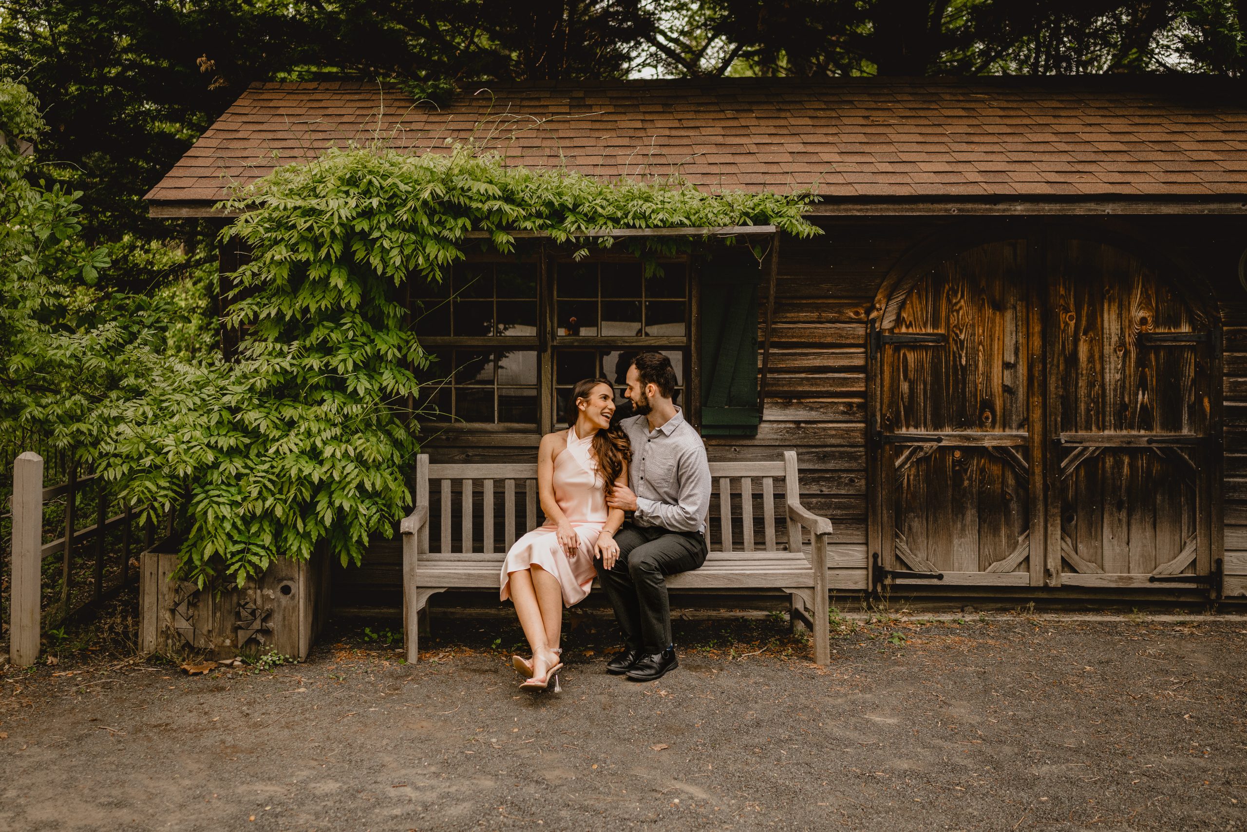 Couple sitting in a bench during their Deep Cut Gardens and Sandy Hook engagement session.