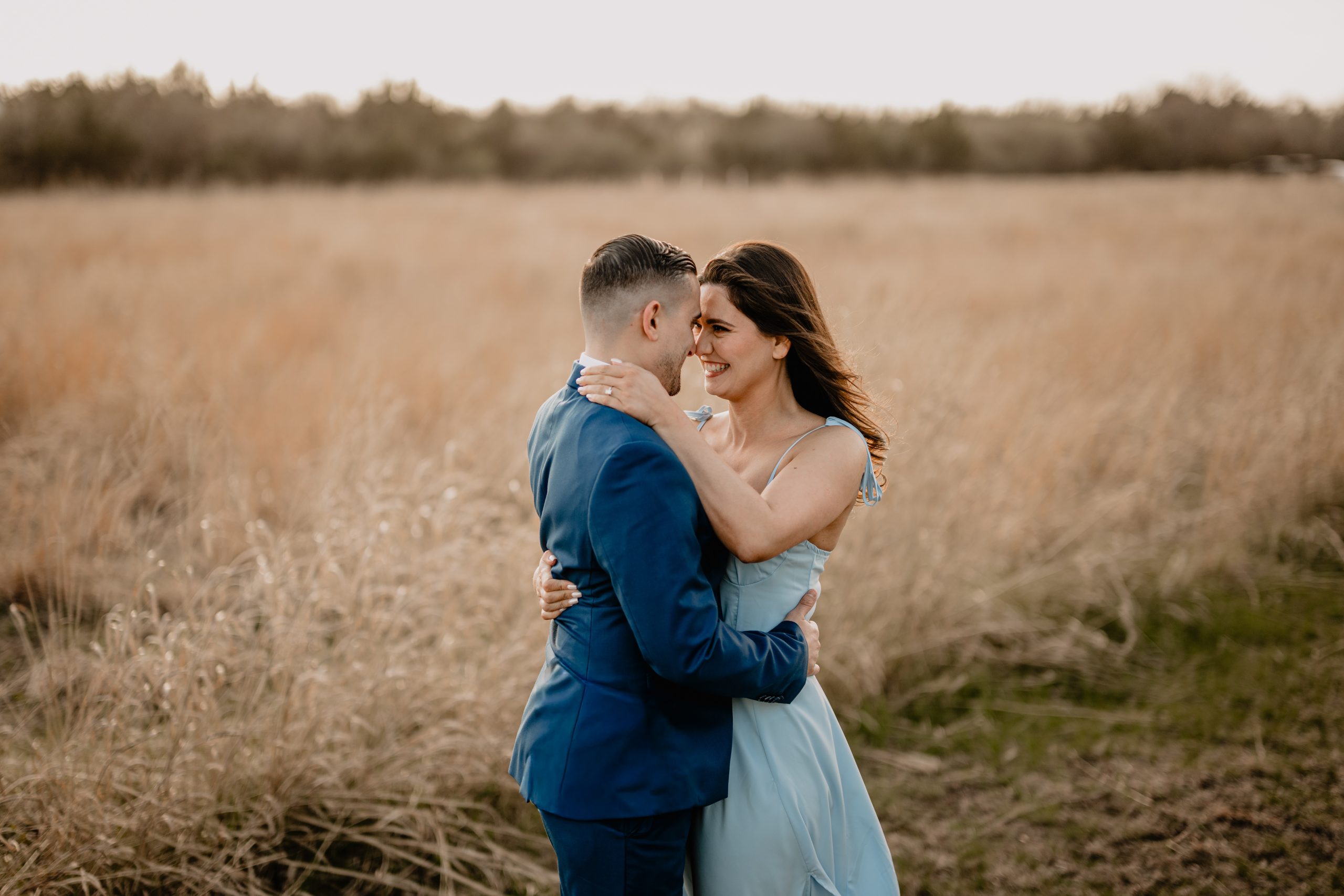 Couple hugging each other on their engagement session at Sandy Hook Beach.