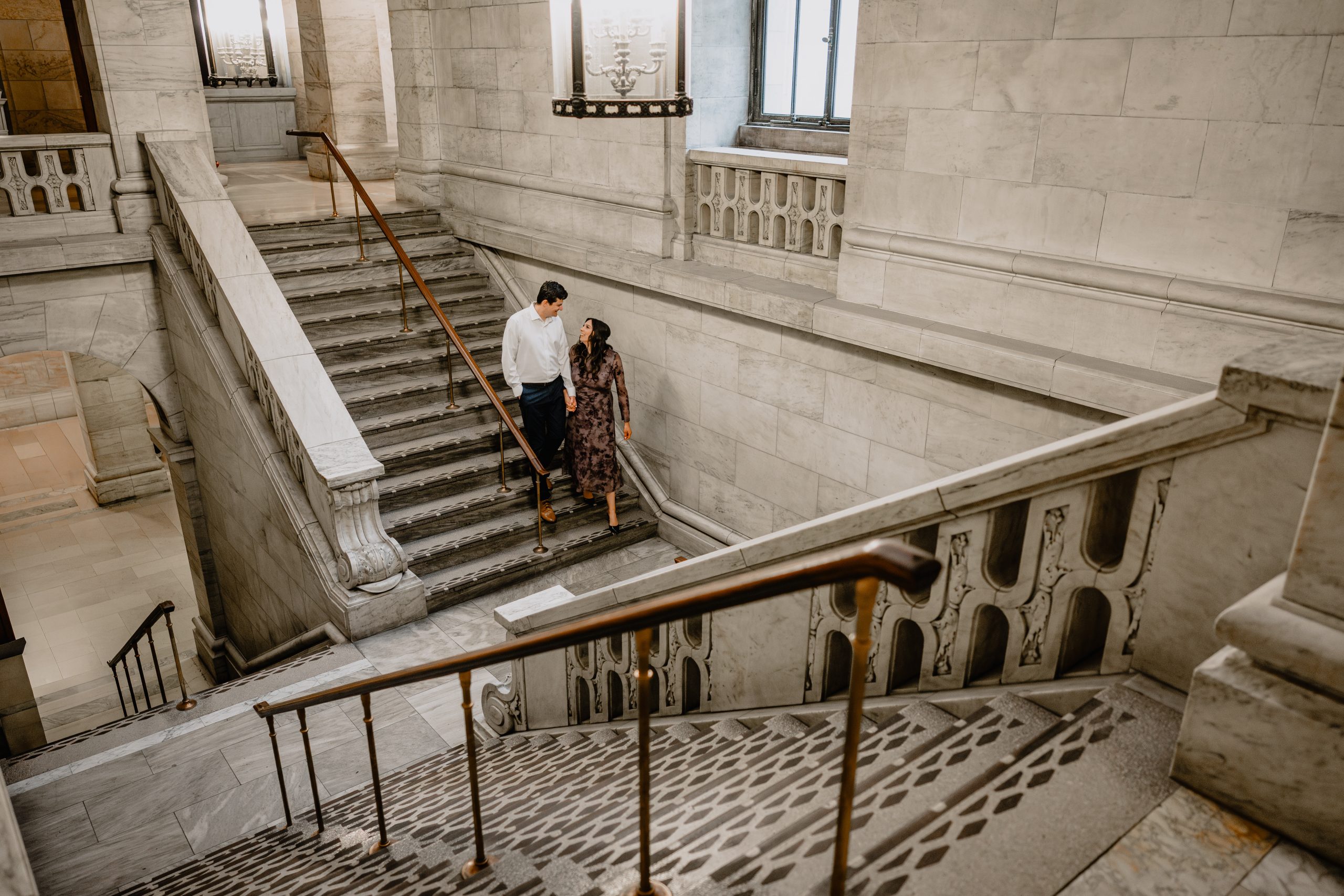 Couple walking down the stairs at their Engagement Session at New York Public Library.