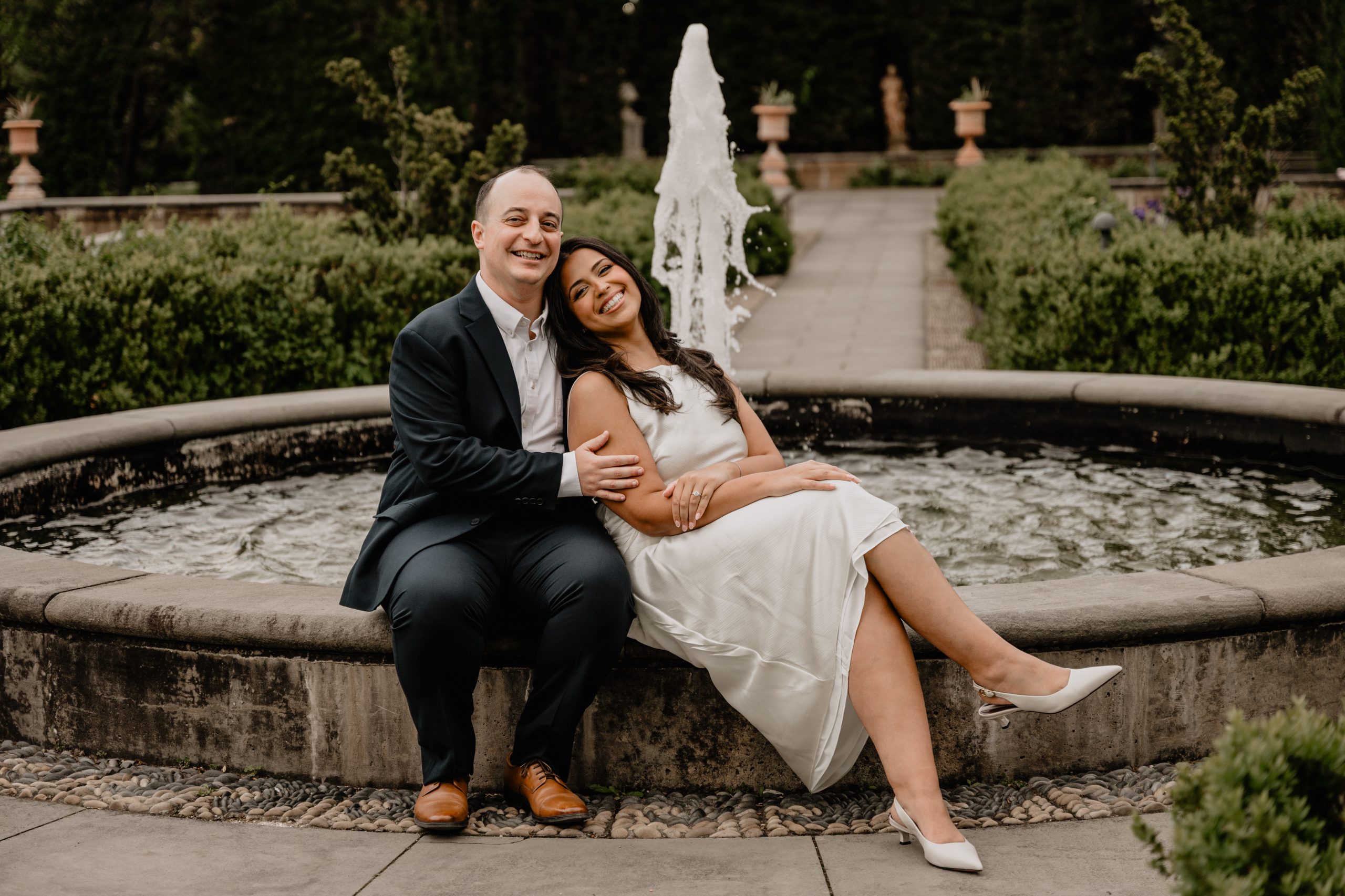 Couple sitting by a fountain during their Staten Island Engagement Session